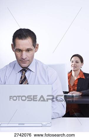Business people working on laptops View Large Photo Image Stock Photograph - Business people working on laptops . Fotosearch