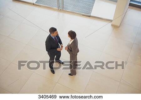 Stock Photo - Business woman and business man standing in office building . Fotosearch