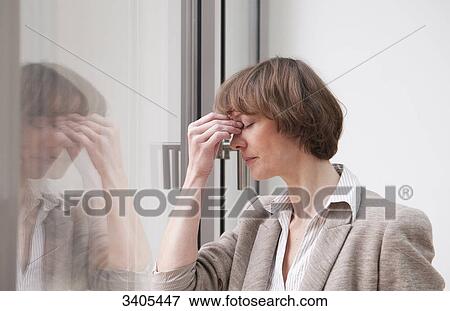 Business woman holding hand at forehead View Large Photo Image Stock Photo - Business woman holding hand at forehead . Fotosearch