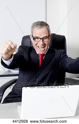 Stock Photo - Businessman cheering in front of laptop . Fotosearch
