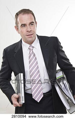 Picture - Businessman holding files and laptop . Fotosearch