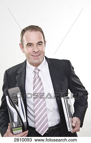 Businessman holding files and laptop  View Large Photo Image Stock Image - Businessman holding files and laptop . Fotosearch