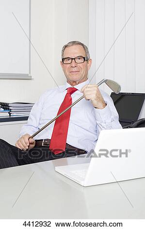 Businessman holding golf club View Large Photo Image Stock Image - Businessman holding golf club . Fotosearch