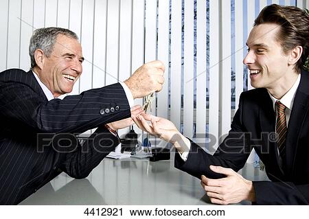 Stock Image - Businessman passing key . Fotosearch
