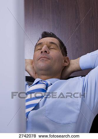 Businessman resting in office View Large Photo Image Stock Photo - Businessman resting in office . Fotosearch