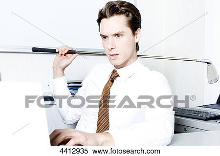 Businessman sitting with golf club in front of laptop View Large Photo Image Stock Photography - Businessman sitting with golf club in front of laptop . Fotosearch