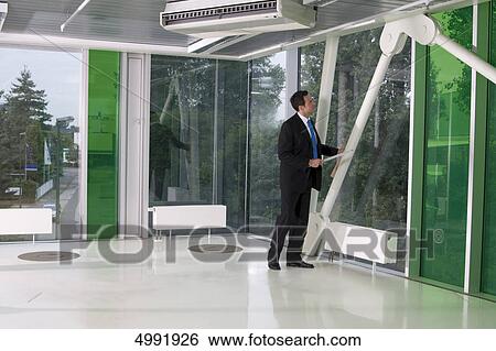 Stock Photograph - Businessman standing at the window . Fotosearch