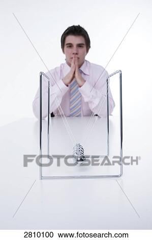 Businessman thinking with pendulum in front of him View Large Photo Image Stock Image - Businessman thinking with pendulum in front of him . Fotosearch