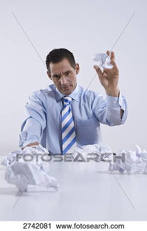 Businessman throwing crumbled papers View Large Photo Image Stock Image - Businessman throwing crumbled papers . Fotosearch