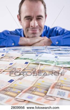 Stock Photograph - Businessman watching European currency . Fotosearch