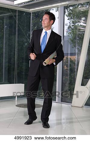 Stock Image - Businessman with roll under his arm . Fotosearch