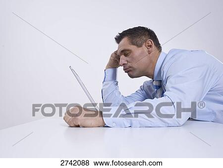 Stock Photo - Businessman working on laptop . Fotosearch
