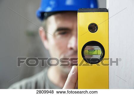 Carpenter holding spirit level View Large Photo Image Stock Photo - Carpenter holding spirit level . Fotosearch