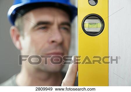 Carpenter holding spirit level View Large Photo Image Stock Photo - Carpenter holding spirit level . Fotosearch