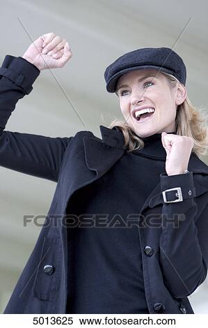 Cheering blond woman wearing cap and coat View Large Photo Image Stock Photography - Cheering blond woman wearing cap and coat . Fotosearch