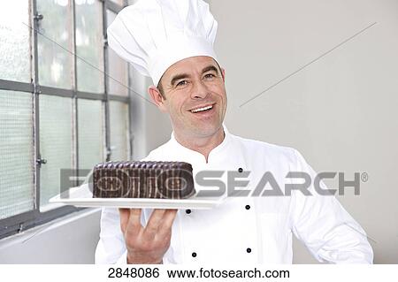 Chef holding chocolate pastry View Large Photo Image Stock Photograph - Chef holding chocolate pastry . Fotosearch