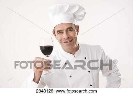 Stock Photograph - Chef holding glass of red wine . Fotosearch