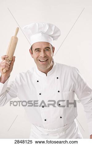 Stock Photography - Chef holding rolling pin and smiling . Fotosearch