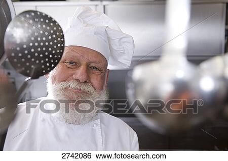 Stock Photograph - Chef holding slotted spoon and smiling . Fotosearch