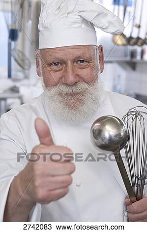 Stock Image - Chef showing thumbs up sign and smiling . Fotosearch