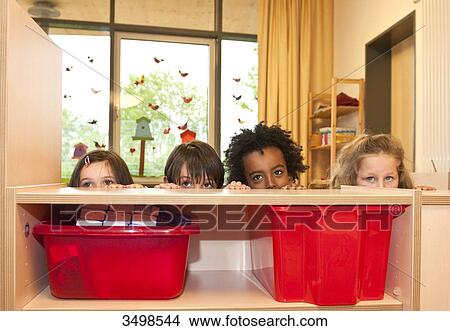 Children hiding behind a shelf View Large Photo Image Picture - Children hiding behind a shelf . Fotosearch