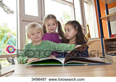 Stock Photo - Children looking at picture book, low angle view . Fotosearch