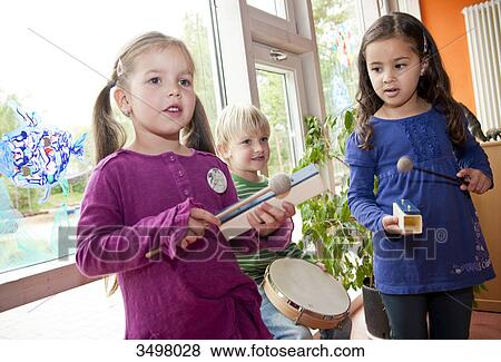 Stock Photo - Children making music in a kindergarten . Fotosearch