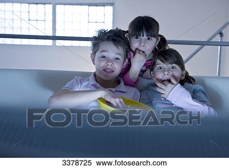 Stock Photography - Children watching TV and eating popcorn, front view . Fotosearch