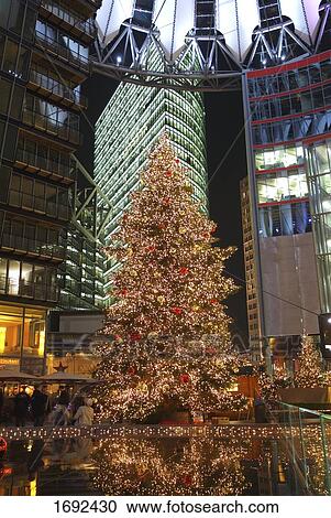 Christmas tree lit up in front of building View Large Photo Image Stock Image - Christmas tree lit up in front of building . Fotosearch