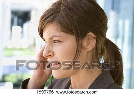 Close-up of businesswoman talking on headset View Large Photo Image Stock Photograph - Close-up of businesswoman talking on headset . Fotosearch