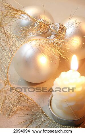 Picture - Close-up of Christmas ornaments with burning candle . Fotosearch