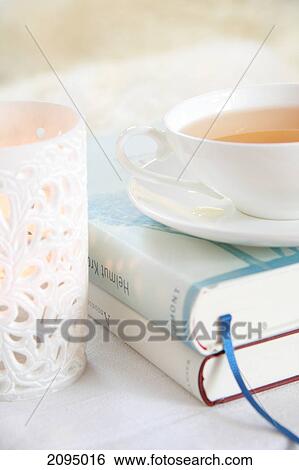 Close-up of cup of herbal tea on books View Large Photo Image Stock Photograph - Close-up of cup of herbal tea on books . Fotosearch