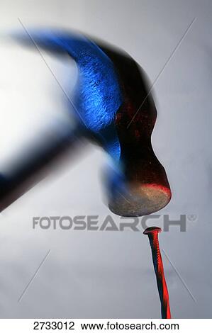 Stock Image - Close-up of hammer hitting nail . Fotosearch