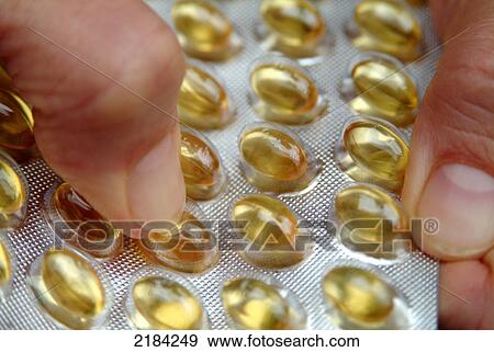 Stock Photo - Close-up of person's hand holding blister pack of medicine . Fotosearch