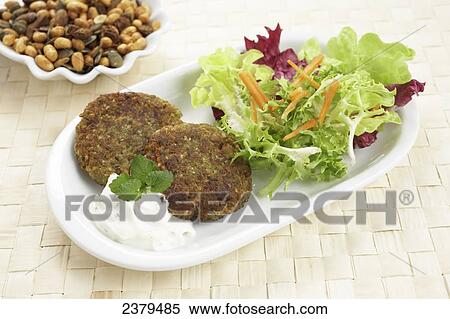 Stock Photography - Close-up of veggie burgers with savoury sauce and salad in tray . Fotosearch