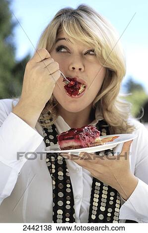 Stock Photo - Close-up of woman eating cake . Fotosearch