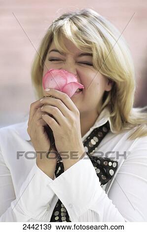 Stock Photo - Close-up of woman smelling rose . Fotosearch