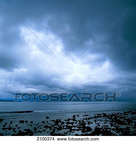 Picture - Clouds over stony beach . Fotosearch
