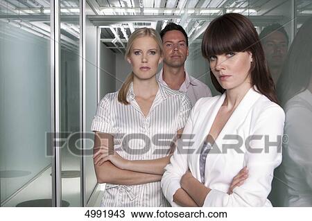 Stock Image - Confident businesspeople standing with arms crossed . Fotosearch