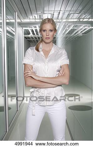 Confident businesswoman standing with arms crossed View Large Photo Image Picture - Confident businesswoman standing with arms crossed . Fotosearch
