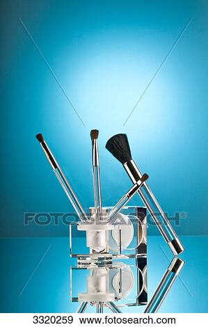 Stock Photo - Cosmetic brushes against blue background . Fotosearch