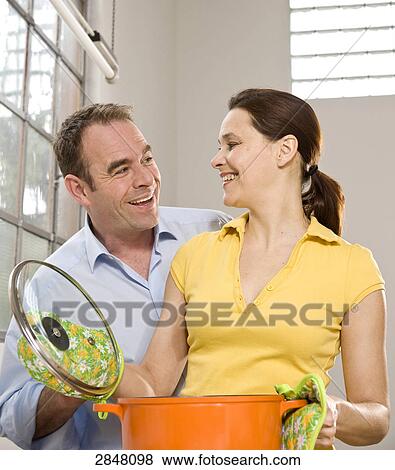 Couple cooking food and romancing View Large Photo Image Stock Photo - Couple cooking food and romancing . Fotosearch