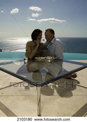 Couple having food at table View Large Photo Image Stock Image - Couple having food at table . Fotosearch