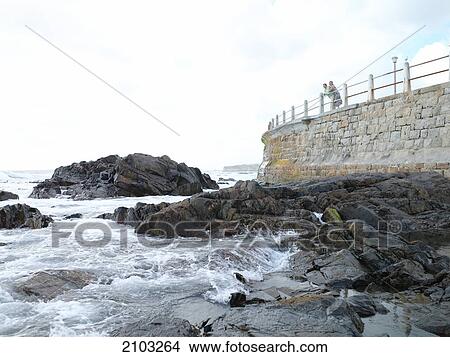 Couple leaning on railing at coast View Large Photo Image Picture - Couple leaning on railing at coast . Fotosearch