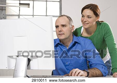 Stock Image - Couple looking at computer screen . Fotosearch