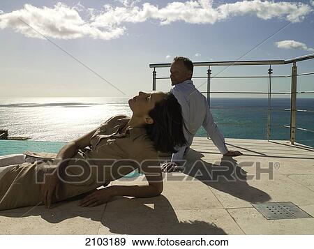 Couple resting at poolside View Large Photo Image Stock Photo - Couple resting at poolside . Fotosearch