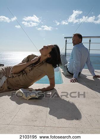 Couple resting at poolside View Large Photo Image Stock Photography - Couple resting at poolside . Fotosearch