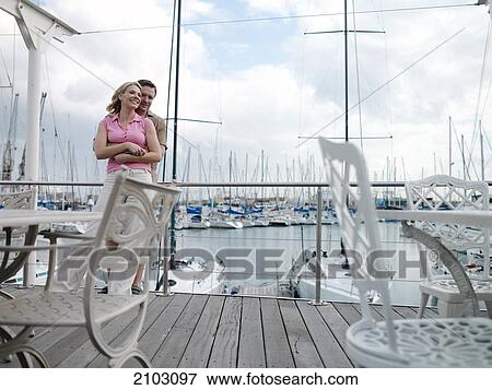 Stock Photo - Couple romancing at harbor . Fotosearch