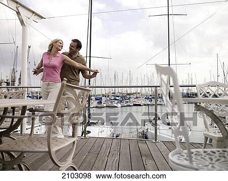 Stock Photo - Couple romancing at harbor . Fotosearch