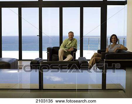 Couple sitting on armchairs View Large Photo Image Stock Photography - Couple sitting on armchairs . Fotosearch